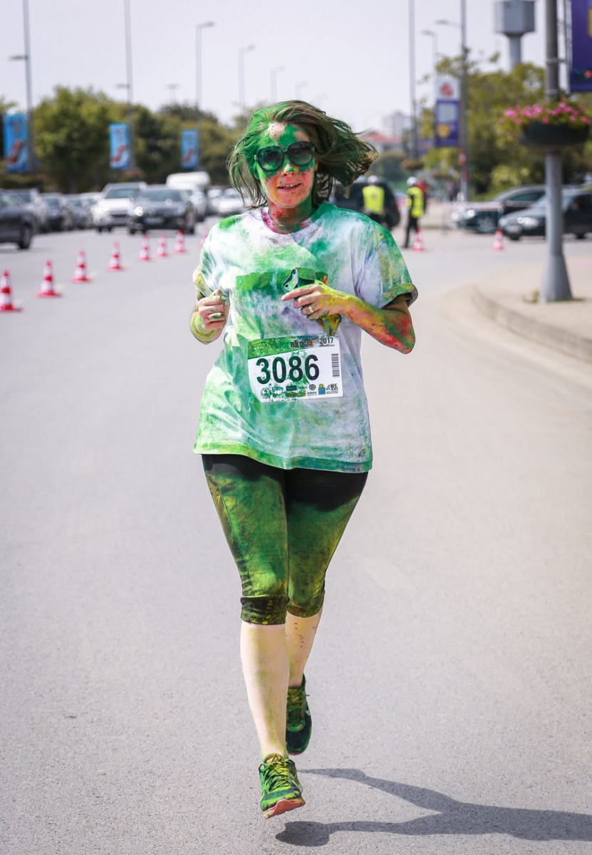 Steph in action at a colour run, covered in green chalk